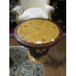 AN ART DECO STYLE WALNUT AND ROSEWOOD OCCASIONAL TABLE the circular moulded top raised on an U