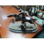 A BRONZE FIGURE modelled as a horse and jockey shown jumping raised on an oval marble base 30cm (h)