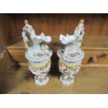 A PAIR OF MEISSEN JUGS each moulded in high relief with frolicking puttis with scroll handle on