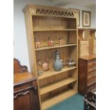 A PINE FIVE TIER OPEN FRONT BOOKSHELF with pierced cresting raised on a platform support 213cm (h)