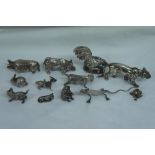 Collection of miniature silver animals including Sumatran rhino, tiger, hedgehog, frog, bull,