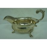 GIII silver sauce boat with scroll handle, shaped border, shell knees on hoof feet, London 1749,