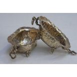 Pair of late Victorian chased silver salts with putti holding ring handles, ribbon and floral