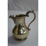 Victorian silver cream jug with bead borders, shell spout and scroll handle, London 1875, maker