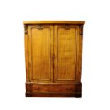 A Victorian mahogany wardrobe with scroll cast detailing to the pediment and twin panelled doors