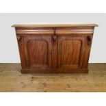 A Victorian mahogany side cabinet with two frieze drawers above two arched panelled cupboard