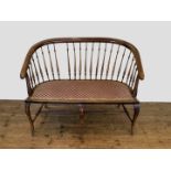 An Edwardian mahogany bench with spindle turned back and oval stuffed seat, on cabriole legs and