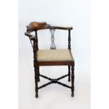 An Edwardian corner chair with fan marquetry inlay to the cresting rail and pierced splat back,