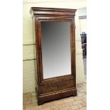 A 19th century French mahogany armoire with shaped pediment, large mirrored door opening to reveal