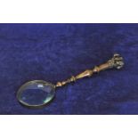 A bronze magnifying glass with bull-dog form finial (glass af). 13ins.