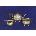 A late Edward VII/early George V silver three piece tea set comprising teapot with ebony finial