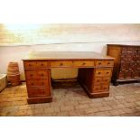A late Victorian oak partners desk with tooled green leather inset top, three frieze drawers and