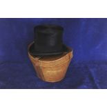 A brown leather top hat box, initialled SWW containing a top hat manufactured by Cristys London