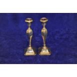 A pair of George V silver candlesticks with circular sconces and hexagonal tapering stems, on out-