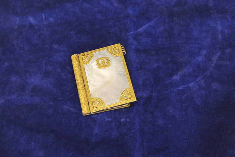 A mother of pearl and gilt mounted pocket book (af).