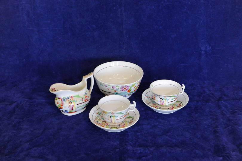 A 19th century porcelain tea set decorated in the Chinese style with figures in a landscape,