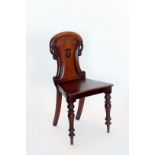 A Victorian mahogany hall chair with rococo scroll carved cresting rail, shield carved splat back