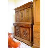 A 19th century French walnut side cabinet with triple carved panel doors with fruiting basket