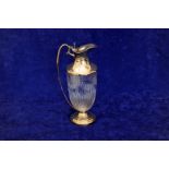 A George V silver claret jug with pierced thumb piece to the cover and loop handle, the swirled