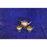 A George V silver tea set comprising teapot with ebony handle and finial, milk jug and twin