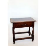 An 18th century oak side table with single frieze drawer on turned legs and flattened stretchers.