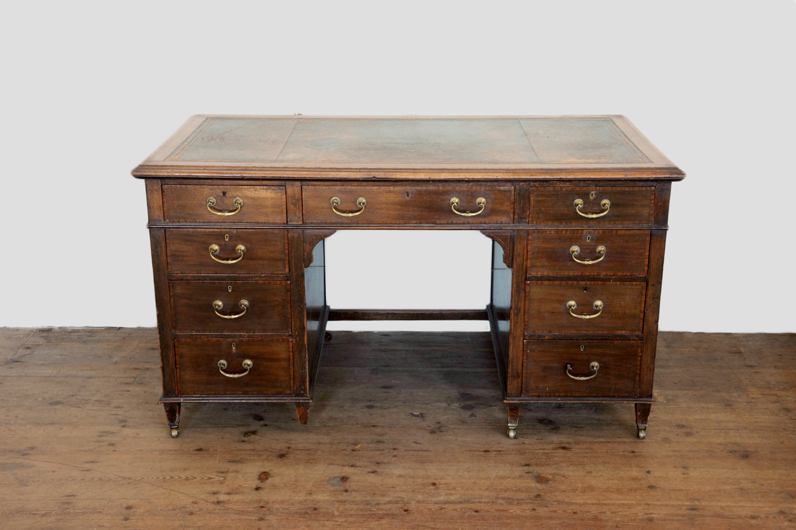 An Edwardian mahogany desk with tooled leather inset top, three frieze drawers and with three
