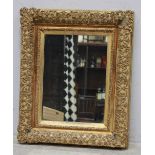 A 19th century gilt-framed mirror, of rectangular form with scrolling strapwork gesso frame,