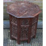 An Eastern carved teak octagonal coffee table with folding stand.