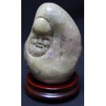 A large soapstone pebble carved in bas relief with the head of a Taoist figure of Longevity, 16cm