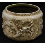 A Bretby pottery jardinière moulded with a continual dragon design to an 'antique' ivory ground,