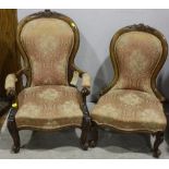 A Victorian walnut armchair and matching nursing chair with foliate-carved crest, scroll-carved arms