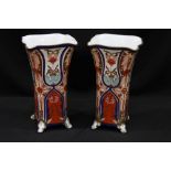 A pair of modern porcelain vases, of square section with flared rims raised on four scrolled feet,