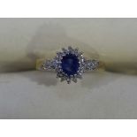 A 9ct gold sapphire and diamond cluster ring claw set with a central sapphire surrounded by