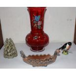 A cranberry glass vase with floral decoration, a Beswick figure of a 'Stonechat', a Wade pottery