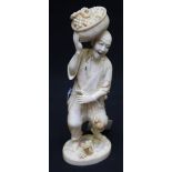 19th century Tokyo School, a carved okimono figure of an old man carrying a basket of grapes on