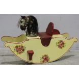 A 20th Century wooden rocking horse, painted yellow with a red trim and decorated with a painted