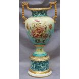 A large Edwardian pottery pedestal vase with gilded and printed floral decoration, 60cm high.