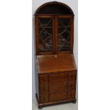 A 1920s oak veneered bureau bookcase, with arched top and open shelf, fall-front enclosing