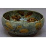 A Royal Doulton stoneware bowl with mottled blue glaze decorated with leaves, 17cm.