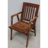 A 20th century teak campaign chair with leather panel seat.