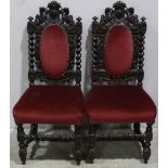 A pair of 19th century stained oak carved standard chairs, in the Jacobean "style", cartouche crests