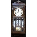 A 1920's wall clock with striking and chiming movement in glazed oak case.