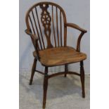 A 19th century yew and elm Windsor armchair, with carved and wheel-pierced shaped splat, turned