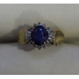 A 10k gold sapphire and diamond cluster ring with leaf design shoulders, claw set with a central