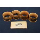 A set of four Mauchlin ware napkin rings and a Mauchlin ware note case each decorated with a local