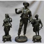 A pair of patinated spelter figures of a couple in Renaissance dress, he with sword and oil lamp,