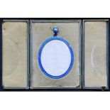 An oval miniature picture frame with blue guilloche enamel frame and suspension loop, 9cm, in gilt-