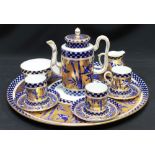 A Coalport porcelain cabaret coffee service, decorated with richly gilded and blue bands of birds,