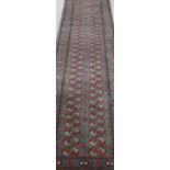 A green ground Persian Bokhara style runner, decorated with two rows of thirty one gulls. 298 x 79