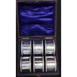 A cased set of six Victorian engraved silver napkin rings, hallmarked London 1880. Combined weight